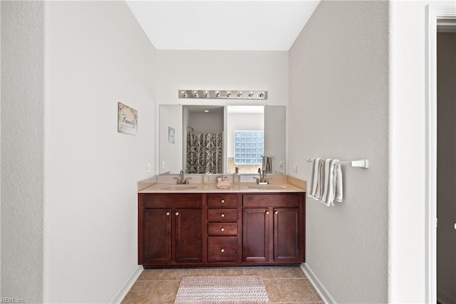 bathroom with baseboards, a sink, a shower with shower curtain, and double vanity