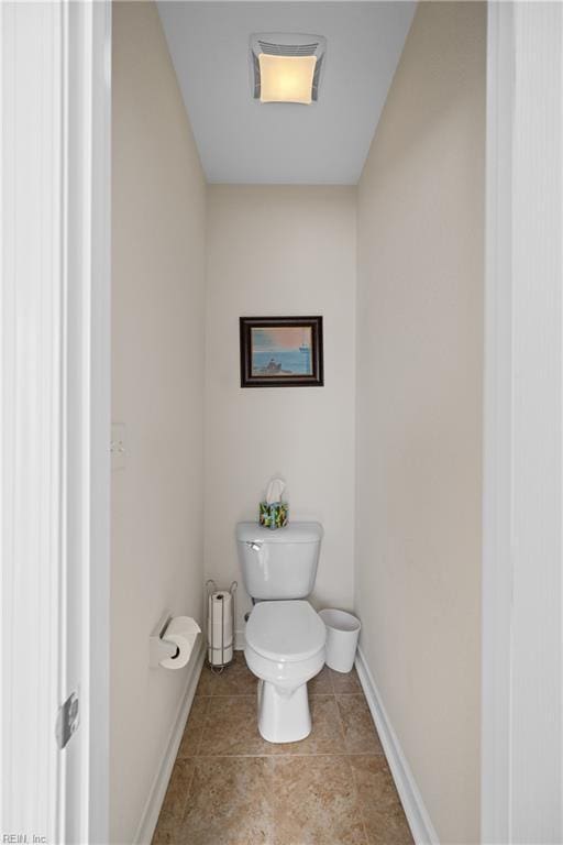 bathroom featuring toilet, tile patterned flooring, and baseboards