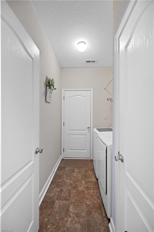 clothes washing area featuring laundry area, baseboards, visible vents, a textured ceiling, and separate washer and dryer