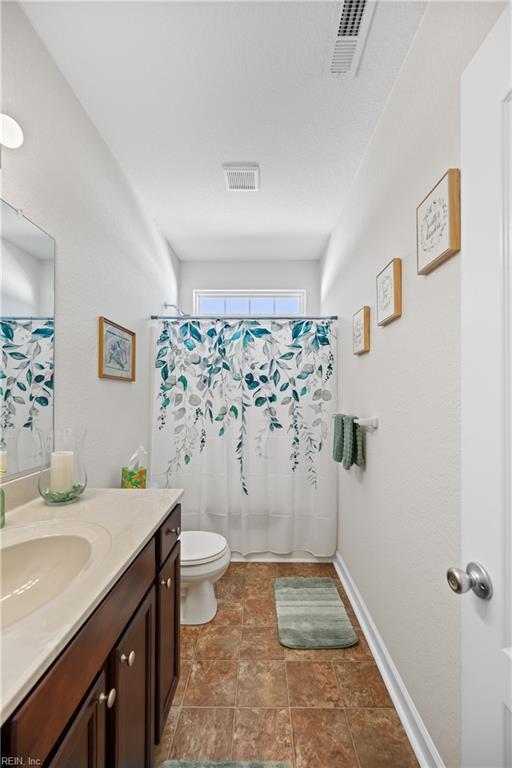 full bathroom with baseboards, visible vents, vanity, and toilet