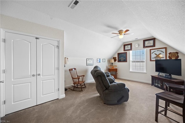 living area featuring carpet floors, visible vents, vaulted ceiling, and a textured ceiling