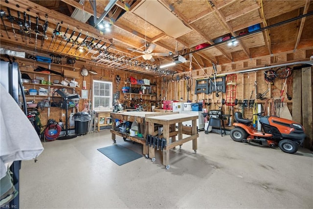 garage with a garage door opener, a ceiling fan, and a workshop area