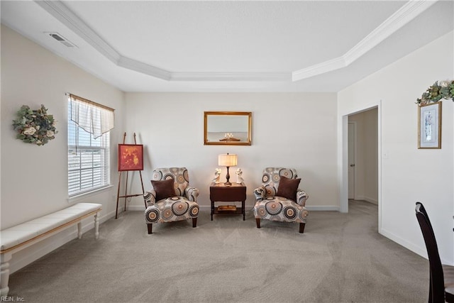 living area with ornamental molding, a tray ceiling, visible vents, and baseboards