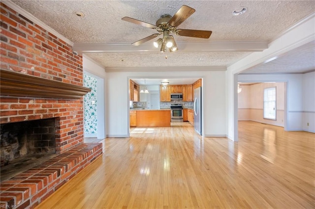 unfurnished living room featuring light wood-style floors, beam ceiling, and a textured ceiling