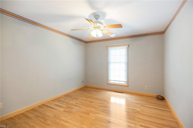 unfurnished room featuring wood finished floors, a ceiling fan, visible vents, baseboards, and ornamental molding