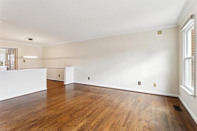 unfurnished room with dark wood-style floors, crown molding, visible vents, and a wealth of natural light