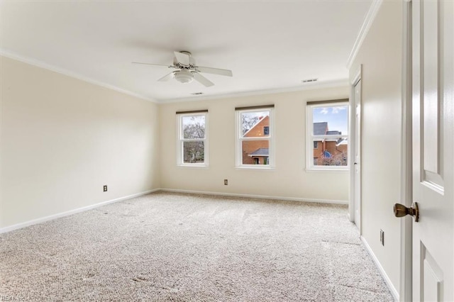 carpeted empty room with baseboards, ornamental molding, and a wealth of natural light