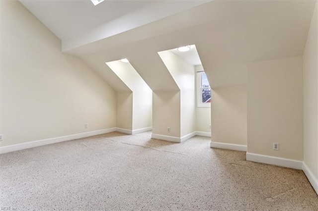 additional living space featuring lofted ceiling, carpet flooring, and baseboards