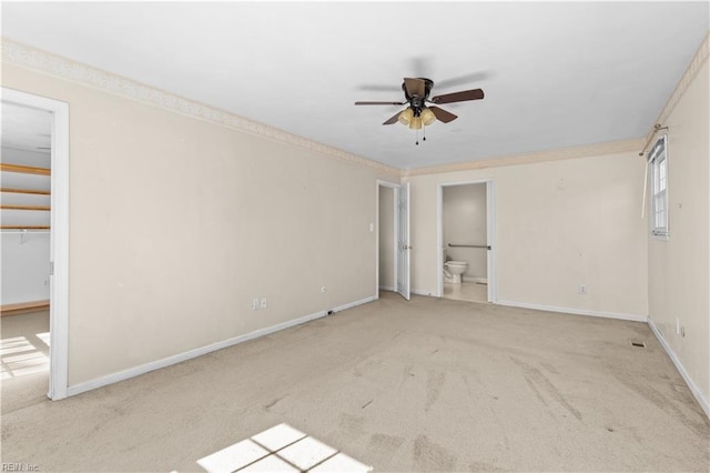 carpeted empty room with crown molding, ceiling fan, and baseboards