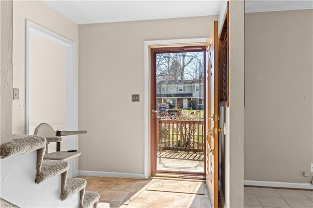 entryway with light tile patterned floors, baseboards, and stairs