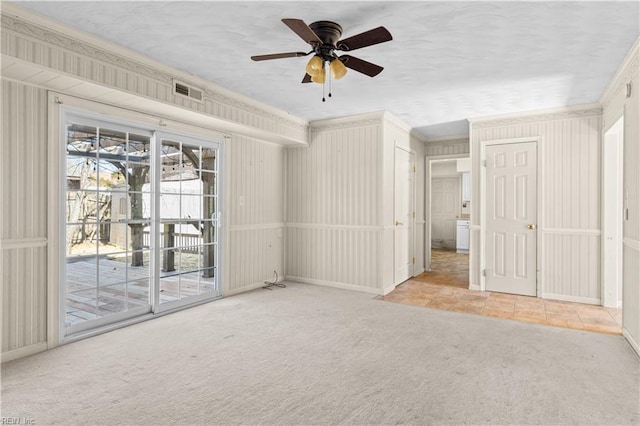 carpeted spare room with crown molding, visible vents, ceiling fan, a textured ceiling, and baseboards