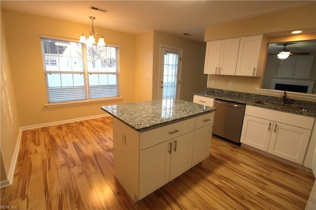 kitchen with visible vents, white cabinets, dishwasher, light wood-type flooring, and a sink