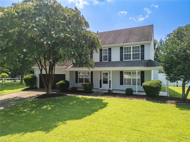 view of front of home featuring covered porch, fence, a front lawn, and concrete driveway