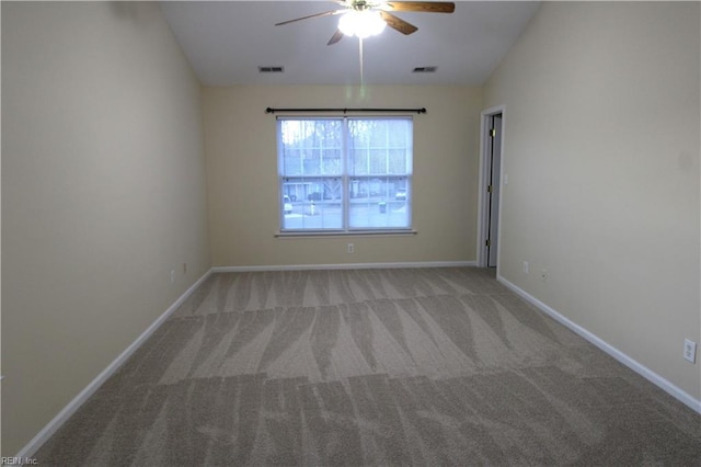 empty room featuring baseboards, visible vents, vaulted ceiling, and carpet flooring