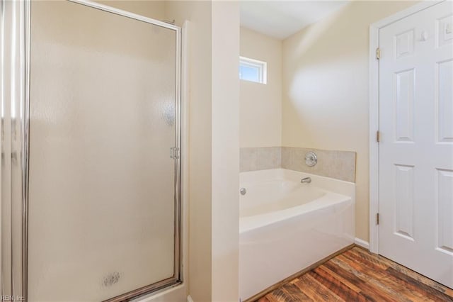 bathroom with wood finished floors, a shower stall, and a bath