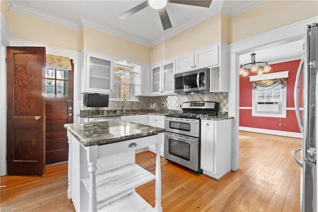 kitchen featuring ornamental molding, tasteful backsplash, white cabinetry, appliances with stainless steel finishes, and light wood finished floors