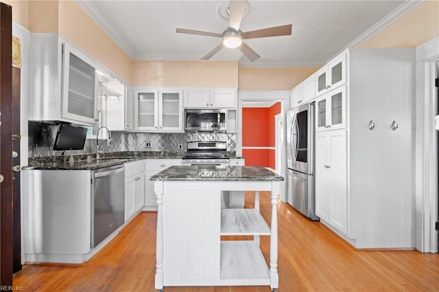 kitchen featuring a sink, dark stone counters, white cabinetry, and stainless steel appliances