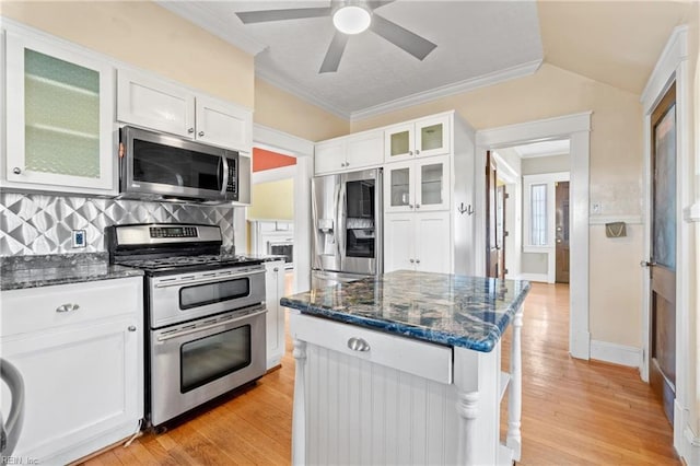 kitchen featuring white cabinetry, dark stone counters, light wood finished floors, and appliances with stainless steel finishes