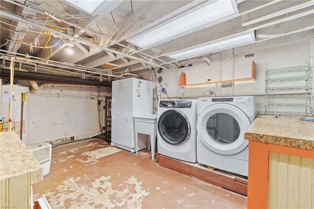 laundry area featuring water heater, laundry area, and washer and dryer