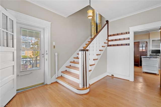 foyer entrance with stairs, hardwood / wood-style flooring, baseboards, and ornamental molding