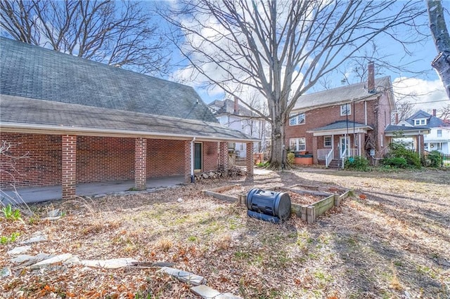 exterior space with brick siding and roof with shingles