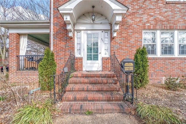 view of exterior entry featuring brick siding