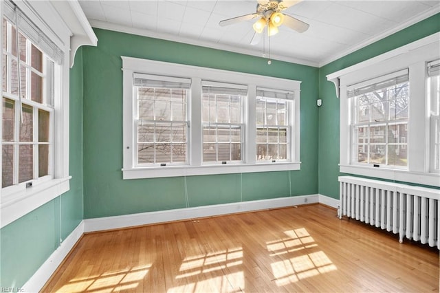 unfurnished sunroom with radiator heating unit and ceiling fan