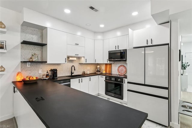 kitchen with visible vents, open shelves, a sink, dark countertops, and appliances with stainless steel finishes