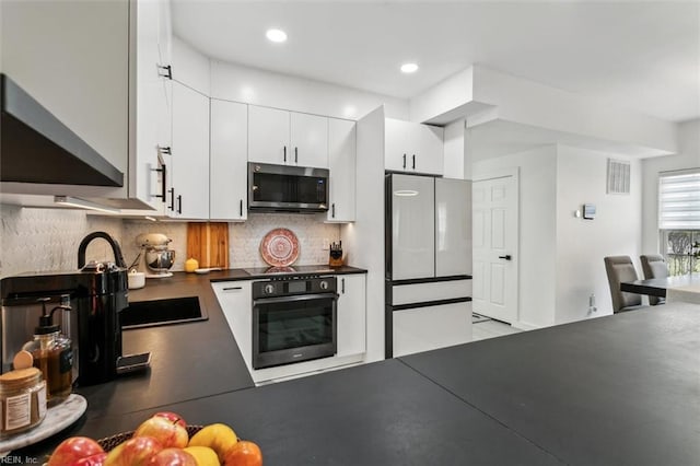 kitchen with visible vents, black appliances, tasteful backsplash, dark countertops, and white cabinets