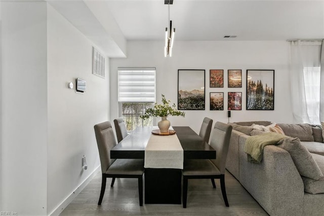 dining room featuring visible vents, baseboards, and wood finished floors