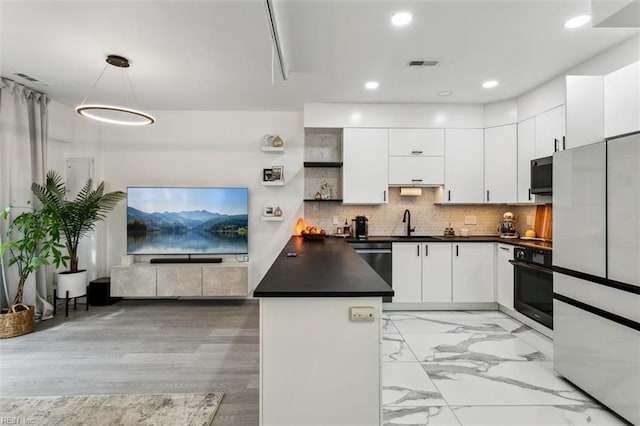 kitchen featuring dark countertops, visible vents, oven, decorative backsplash, and a peninsula