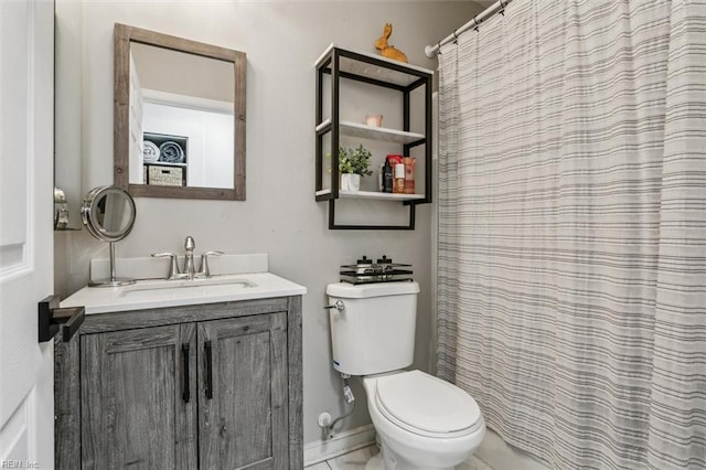 bathroom with toilet, vanity, and baseboards