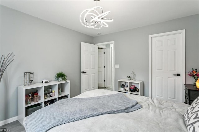 bedroom with baseboards and a chandelier