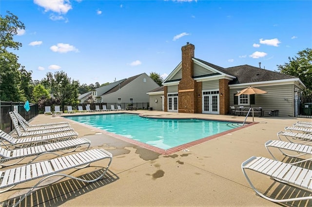 pool featuring french doors, a patio, and fence