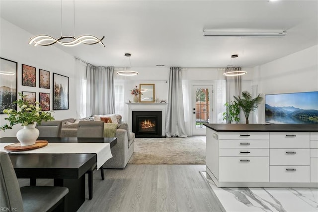 living room featuring a wall mounted air conditioner and a lit fireplace