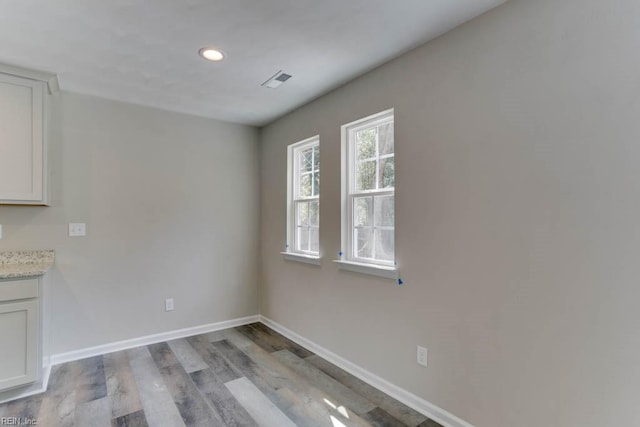 unfurnished dining area with light wood-style floors, recessed lighting, visible vents, and baseboards