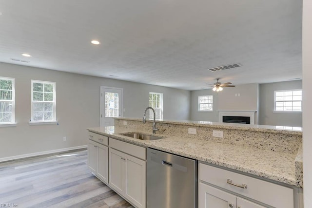 kitchen featuring dishwasher, plenty of natural light, a sink, and visible vents