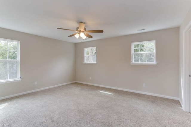 empty room with ceiling fan, visible vents, baseboards, and carpet flooring