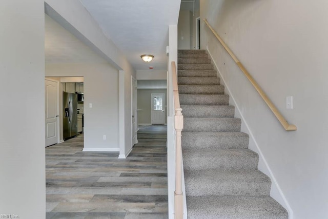 staircase with wood finished floors and baseboards