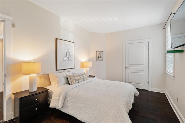 bedroom featuring visible vents, baseboards, and dark wood-type flooring