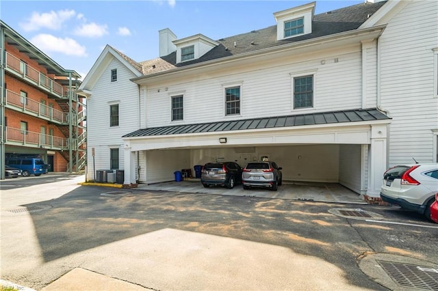 view of front of house with metal roof, covered parking, and a standing seam roof