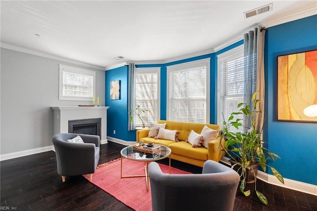 living area with ornamental molding, a wealth of natural light, visible vents, and baseboards