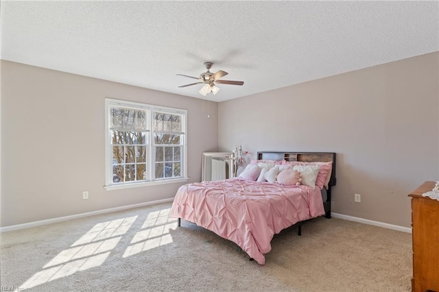 bedroom with baseboards, a textured ceiling, carpet floors, and a ceiling fan