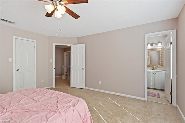 unfurnished bedroom with visible vents, baseboards, ceiling fan, light colored carpet, and ensuite bathroom