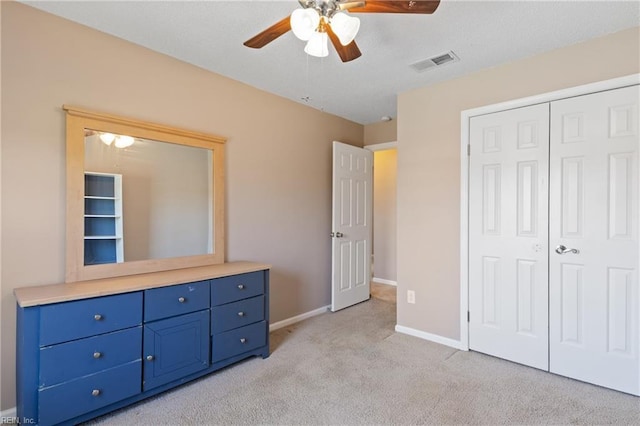 unfurnished bedroom with a ceiling fan, baseboards, visible vents, a closet, and light carpet