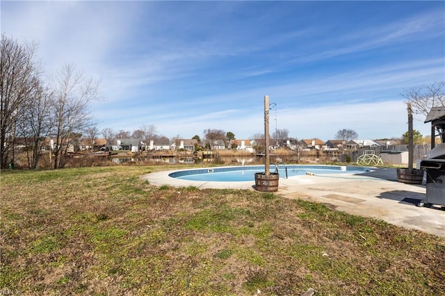 outdoor pool featuring a lawn