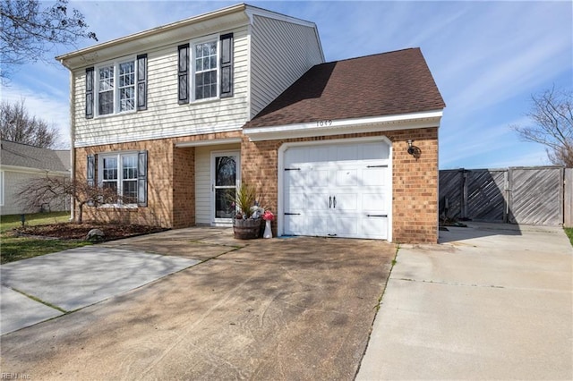 traditional home featuring brick siding, fence, roof with shingles, a garage, and driveway