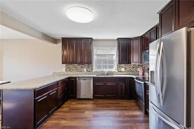 kitchen featuring a sink, stainless steel appliances, a peninsula, and dark wood-style flooring