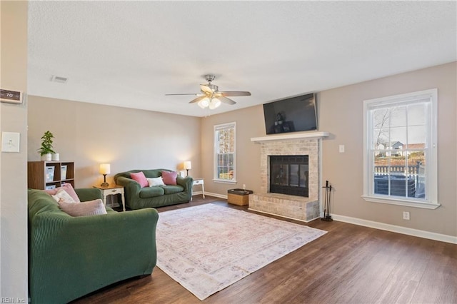 living area featuring dark wood finished floors, plenty of natural light, and a fireplace