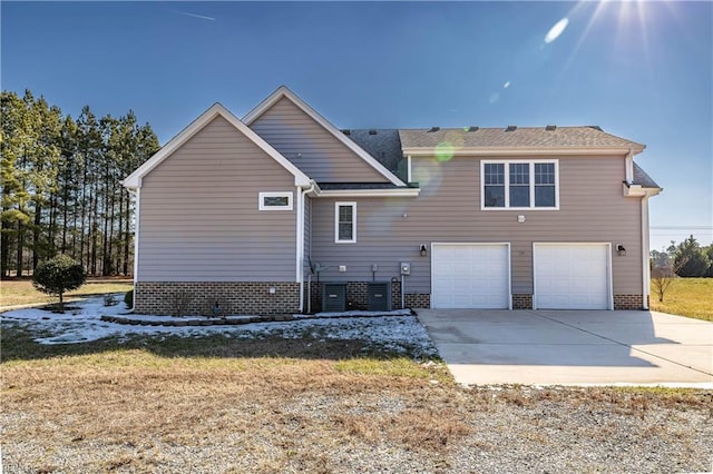 rear view of house with driveway and an attached garage